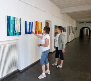 zwei Personen betrachten Bilder im Gang