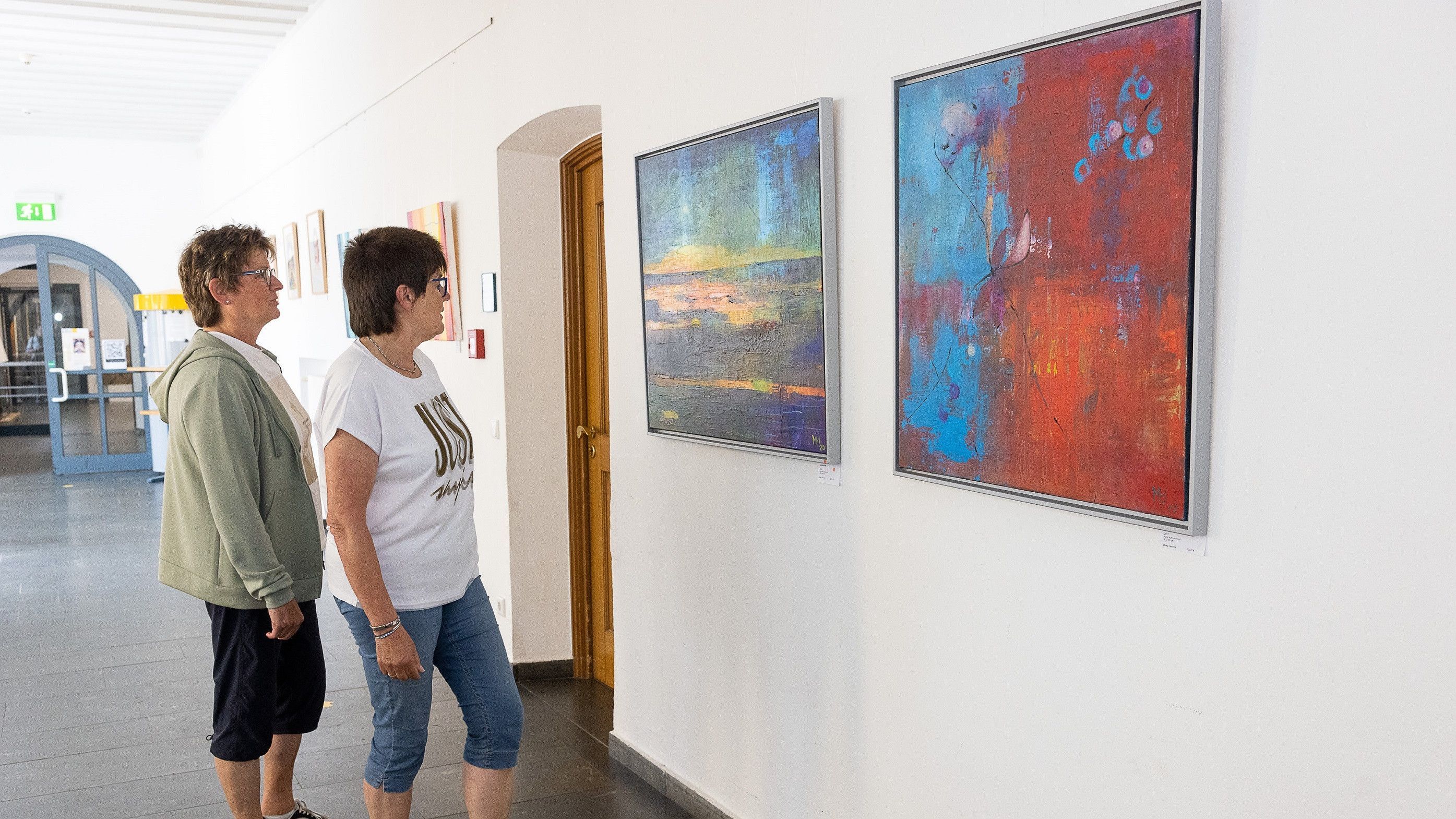 zwei Personen betrachten Bilder