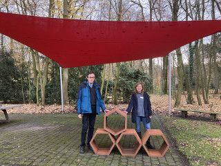 Zwei Personen neben vier Hexagon 