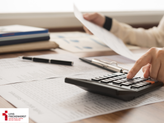 Zettel, Taschenrechner und ein Stift auf einem Schreibtisch